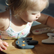 An actual baby playing with three of BabyGlitch's chewable baby controllers.